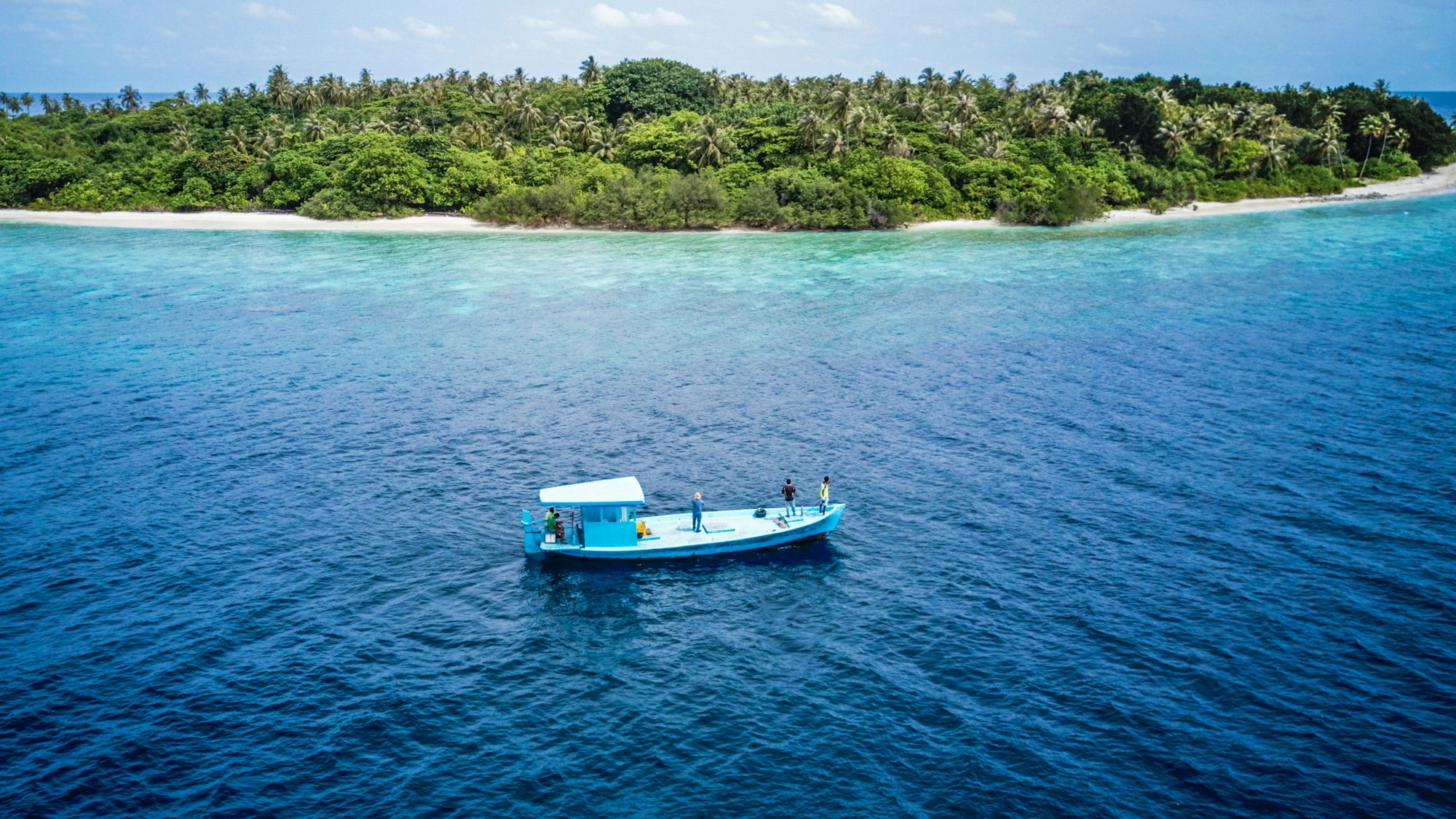 Small boat off a tropical island coastline